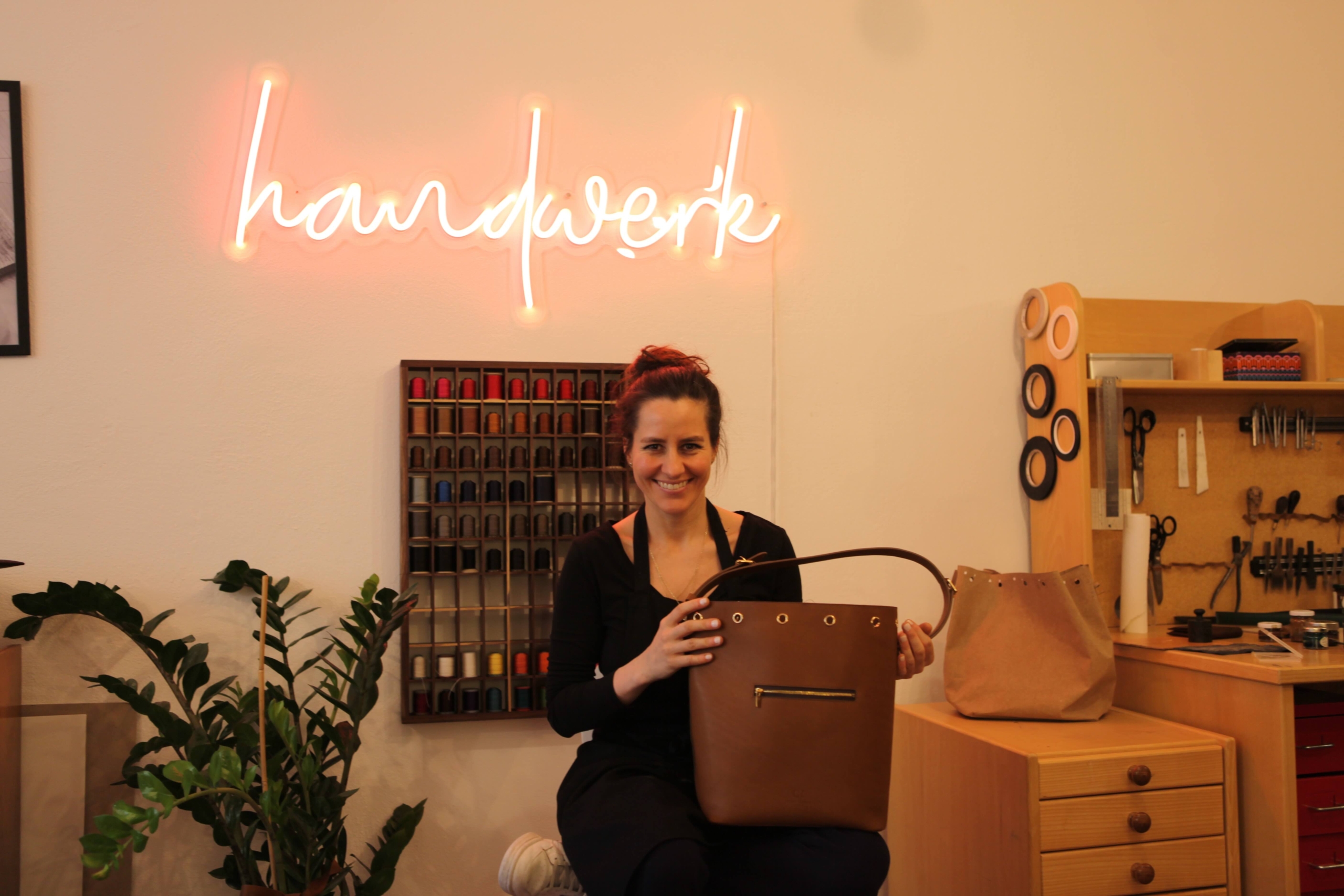 A person with a red hair bun sits in a workshop, embodying the spirit of 