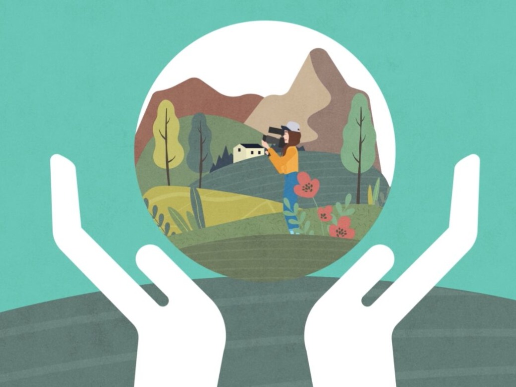 Illustration of two white hands cupping a circle containing a scenic, green-producing landscape. Inside the circle, a person with a camera stands in a field with mountains, trees, and a house in the background. The background outside the circle is teal.